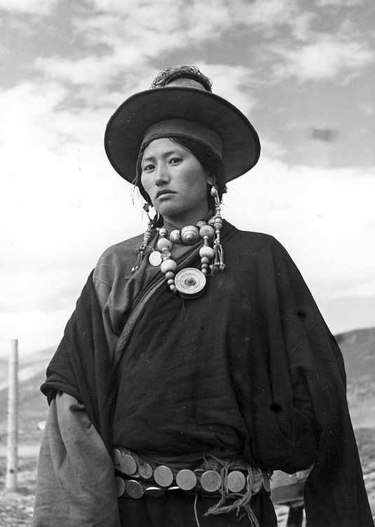 Tibet - Tibeťanka. Na krku bohaté korále a stříbrná schránka s amuletem gau.